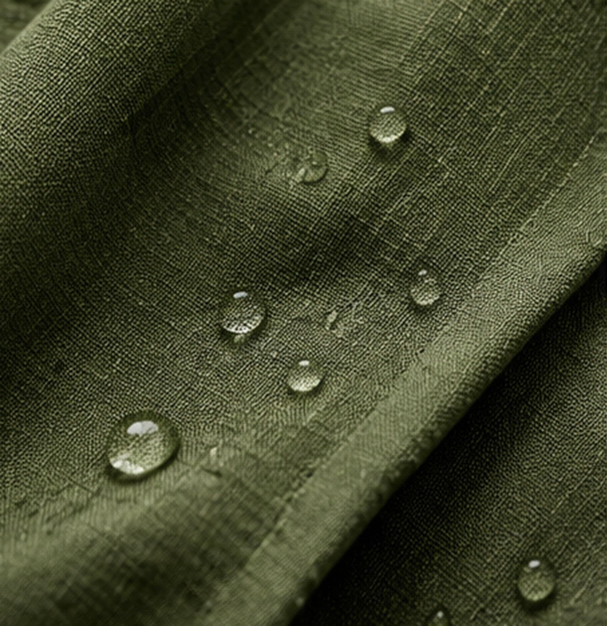 Close-up of water droplets beaded on olive-green woven fabric.
